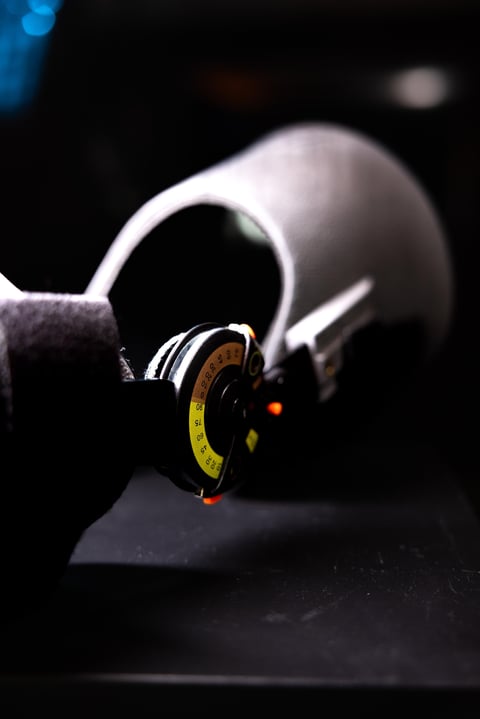 Close-up of headphones with illuminated orange dial on dark surface against blurred background
